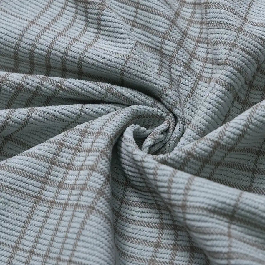 Soft 16-wale corduroy fabric from Longan Craft, featuring a light blue base with a brown plaid print and ribbed texture. The Plaid Print 16 Wale Corduroy Fabric By The Yard is gathered at the center to showcase its gentle folds and plush surface, making it ideal for pants and other premium projects.