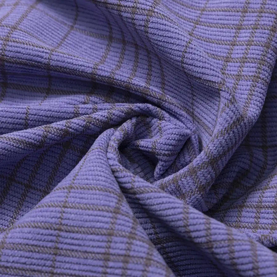 Close-up of the Longan Craft Plaid Print 16 Wale Corduroy Fabric By The Yard, featuring a colorful purple design with fine gray plaid lines, gathered and twisted at the center. This premium fine wale corduroy material is ideal for sewing stylish and textured projects like pants.