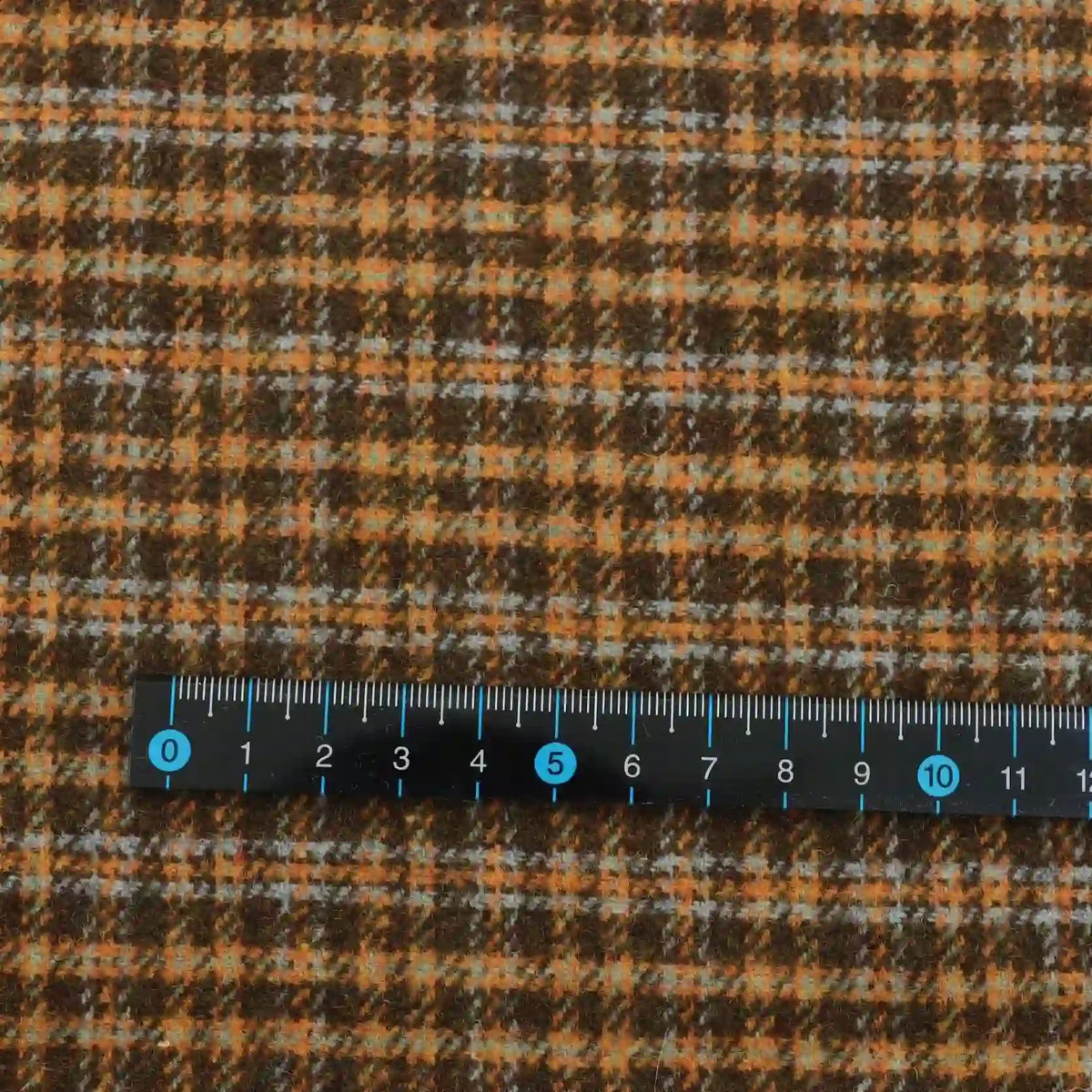 Plaid Wool Fabric By The Yard in brown, orange, and blue brushed plaid, shown with a ruler for scale.