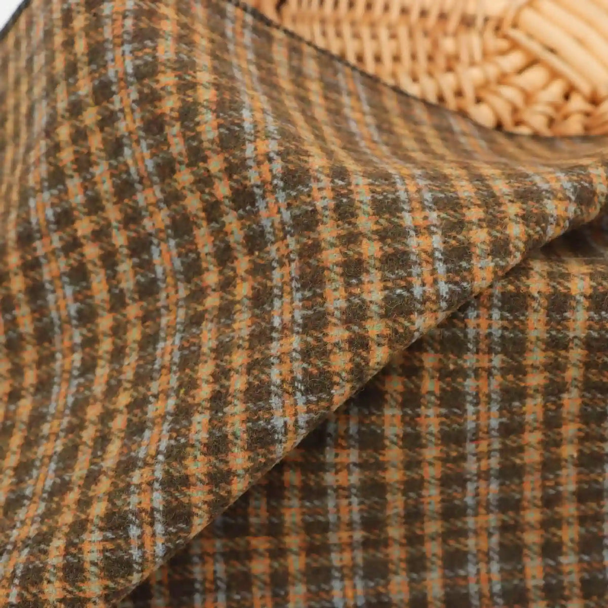 Folded heavyweight Plaid Wool Fabric By The Yard in a brown, orange, and light blue brushed plaid pattern.