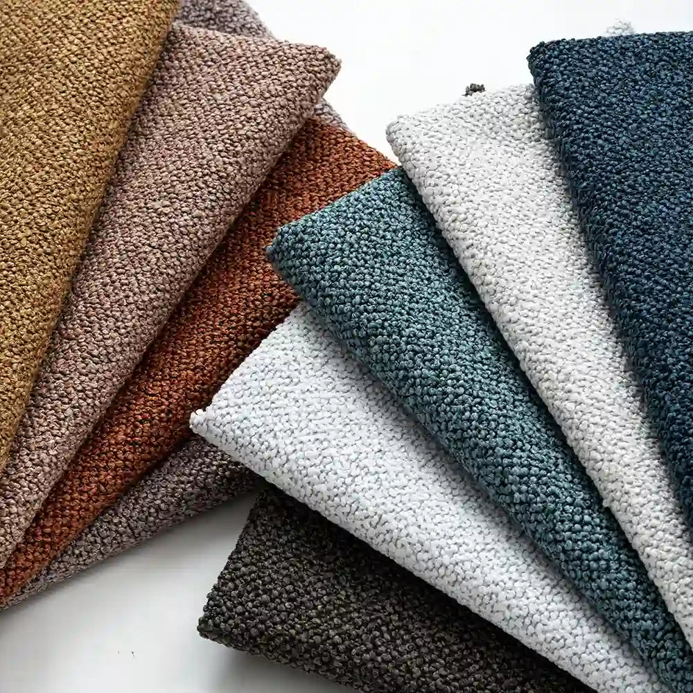 A fan arrangement of Longan Craft Plain Color Boucle Fabric By The Yard, a thick polyester boucle upholstery material, is shown in brown, rust, gray, teal, blue, and white on a white surface.