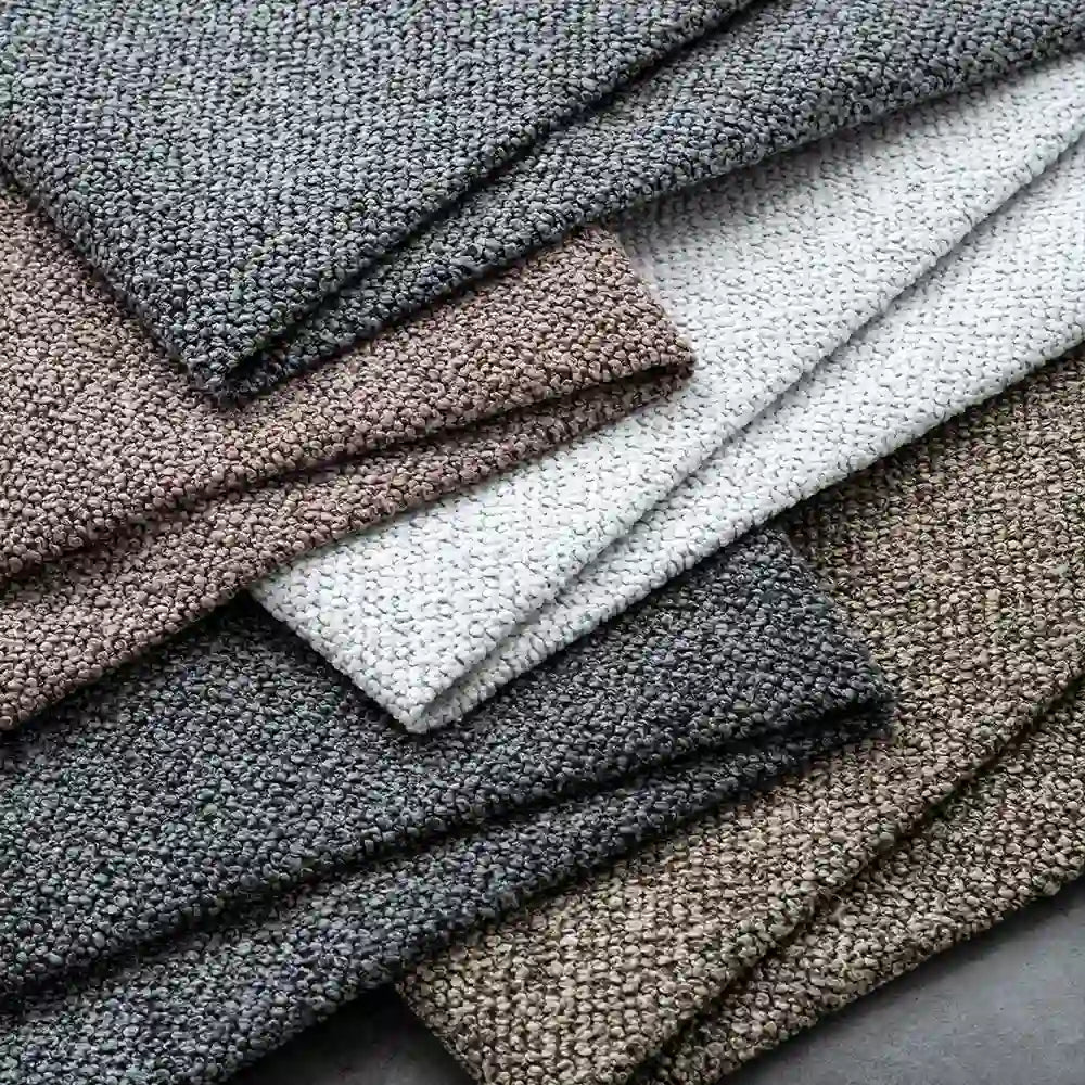 Multiple folded pieces of Longan Craft's Plain Color Boucle Fabric by the yard, made from thick polyester in neutral shades—gray, beige, white, and brown—are neatly stacked for a classic look.