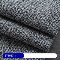 Close-up of thick, textured gray Plain Color Boucle Fabric By The Yard from Longan Craft, featuring a small, tightly looped pattern. Label at bottom left reads SY1087-1 in white on blue. Perfect for upholstery projects.