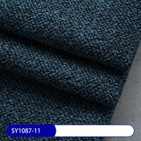 A close-up of textured dark blue Plain Color Boucle Fabric By The Yard from Longan Craft, folded in layers to show its detailed weave. A label at the bottom displays SY1087-11 in white on a blue background.
