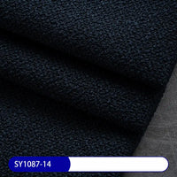 A close-up of folded, textured dark navy blue Plain Color Boucle Fabric By The Yard from Longan Craft on a gray surface, with label SY1087-14—thick polyester boucle perfect for upholstery or drapery fabric projects.