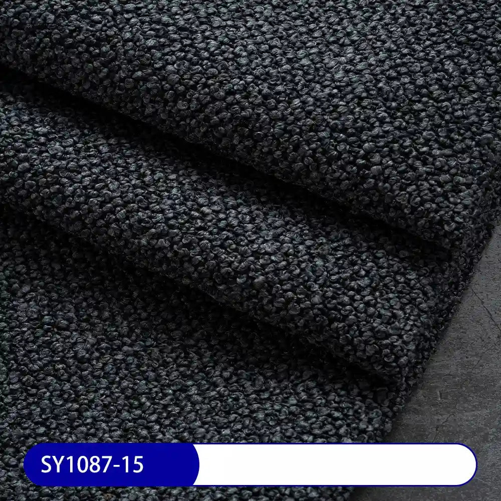 Close-up of folded Longan Craft Plain Color Boucle Fabric By The Yard, featuring a thick pebbled polyester surface—perfect for drapery or upholstery. A white and blue label at the bottom left shows the code SY1087-15.