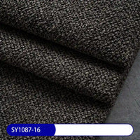 A close-up shows dark, textured Plain Color Boucle Fabric By The Yard from Longan Craft (SY1087-16) folded in layers on a blue and white label—perfect for upholstery or drapery with thick polyester boucle material.