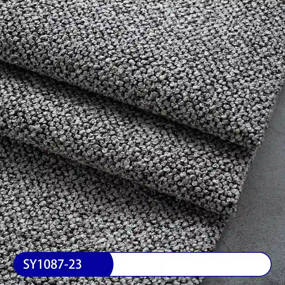Close-up of folded gray Plain Color Boucle Fabric By The Yard from Longan Craft, thick polyester boucle with a tightly looped surface. Label shows SY1087-23, ideal for drapery or upholstery fabric projects.