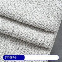 Close-up of three overlapping sheets of Longan Craft Plain Color Boucle Fabric By The Yard, featuring thick polyester boucle material in a light gray pebble pattern on a dark gray surface, with label SY1087-6 at the bottom left.