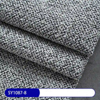 Close-up of three overlapping pieces of Longan Craft Plain Color Boucle Fabric By The Yard, thick polyester upholstery material in textured gray, with a label reading SY1087-8—ideal for versatile upholstery projects.