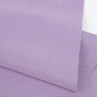 A close-up of two overlapping pieces of Longan Craft Plain Color French Terry Fabric in light purple, showcasing the soft, smooth polyester texture and visible weave—ideal for winter clothing.