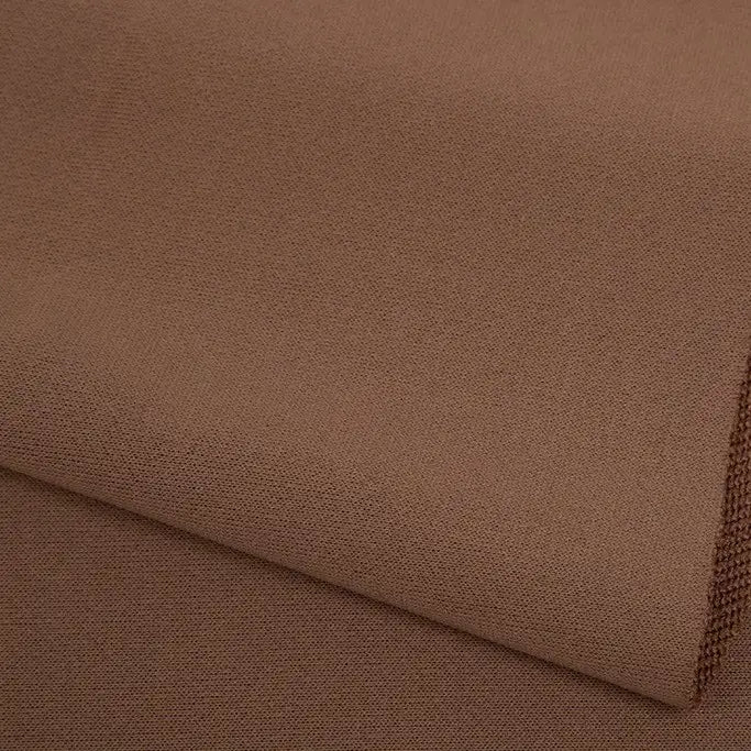 A close-up of Longan Craft's Plain Color French Terry Fabric by the yard, crafted from soft polyester with a subtle woven texture, shown neatly folded in layers—ideal for winter clothing.