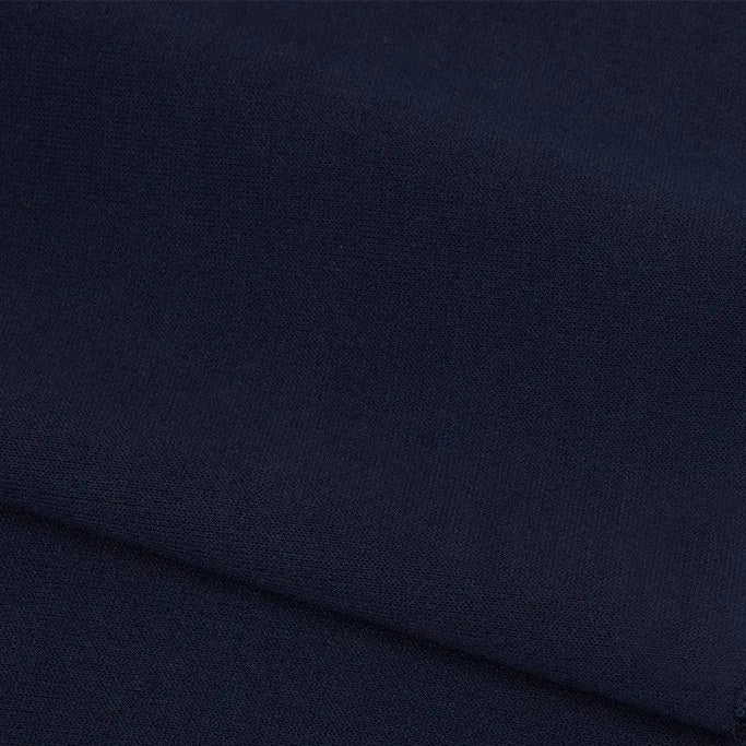 A close-up of Longan Craft's Plain Color French Terry Fabric By The Yard showcases its smooth, dark navy polyester texture with a subtle weave and gentle folds, ideal as a soft, premium material for winter clothing.