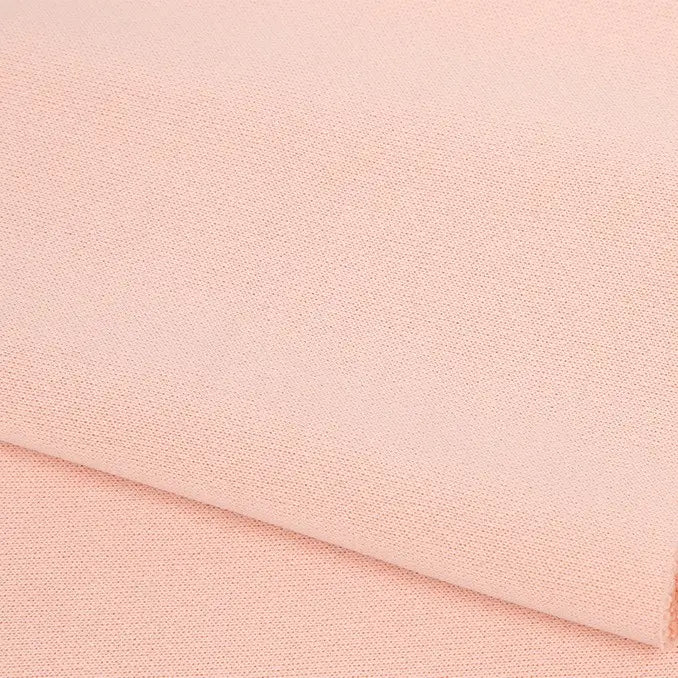 A close-up of Longan Craft's Plain Color French Terry Fabric by the yard, in light peach polyester, showing its soft texture—ideal for winter clothing.