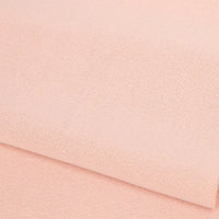 A close-up of Longan Craft's Plain Color French Terry Fabric by the yard, in light peach polyester, showing its soft texture—ideal for winter clothing.