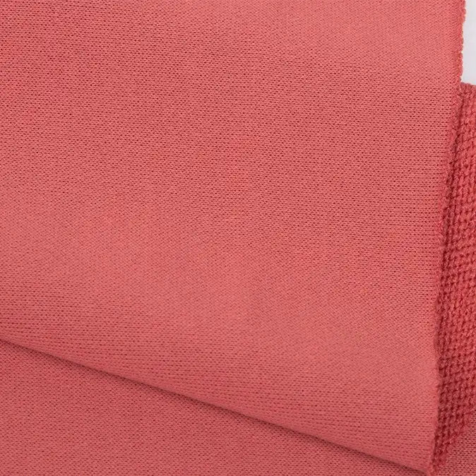 A close-up of Longan Craft’s Plain Color French Terry Fabric by the yard in dusty rose, highlighting the soft polyester material’s weave and neatly finished edges—ideal for winter clothing.