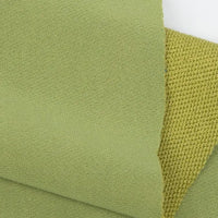Two pieces of Longan Craft Plain Color French Terry Fabric by the yard, in light green, overlap. One is smooth with a tight weave; the other has a rougher texture and visible weave pattern. Both are soft polyester French terry for winter clothing.