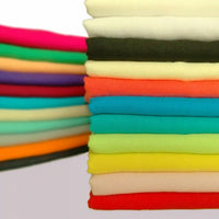 Neatly stacked layers of Longan Craft’s Plain Color Jersey Viscose Fabric By The Yard—100% rayon viscose in vibrant pink, green, yellow, orange, blue, and cream—ideal for dresses. All fabrics shown on a clean white background.