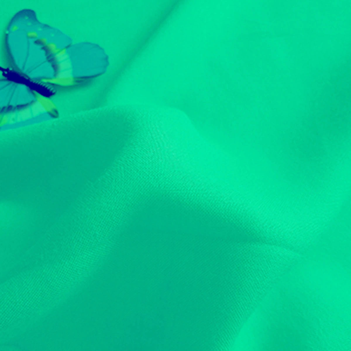 A blue butterfly rests on Longan Craft's Plain Color Jersey Viscose Fabric, a soft 100% rayon material with gentle folds—perfect for dresses and sold by the yard.