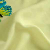 A close-up of pale yellow Plain Color Jersey Viscose Fabric by Longan Craft, made from 100% rayon viscose and featuring a soft, smooth texture. A decorative blue and yellow butterfly appears in the top left corner.