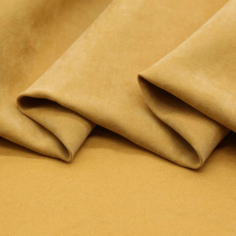 Close-up of Longan Craft’s Multi Color Microsuede Polyester Peachskin Fabric, featuring a soft, mustard yellow brushed peach skin texture with gentle folds—ideal for cozy clothing and sold by the yard.