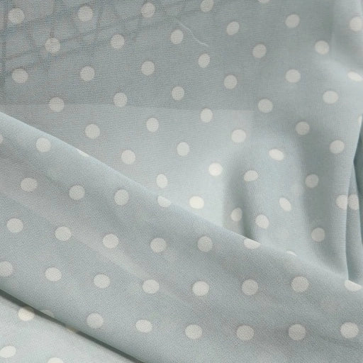 Light blue Polka Dot Print Chiffon Fabric By The Yard draped in soft, sheer folds.