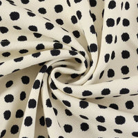 A detailed close-up of Longan Craft’s Polka Dot Print Corduroy Fabric By The Yard showcases its cream-colored, fine wale corduroy material twisted into a spiral at the center. The raised dotted pattern and soft texture of this retro corduroy apparel textile are clearly visible.