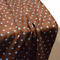 Brown Polka Dot Printed 21 Wales Corduroy Fabric By The Yard with a repeating pattern of light blue polka dots.