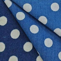 Polka Dot Printed Denim Fabric By The Yard in dark light blue with a repeating white polka dot pattern, shown with a fold.