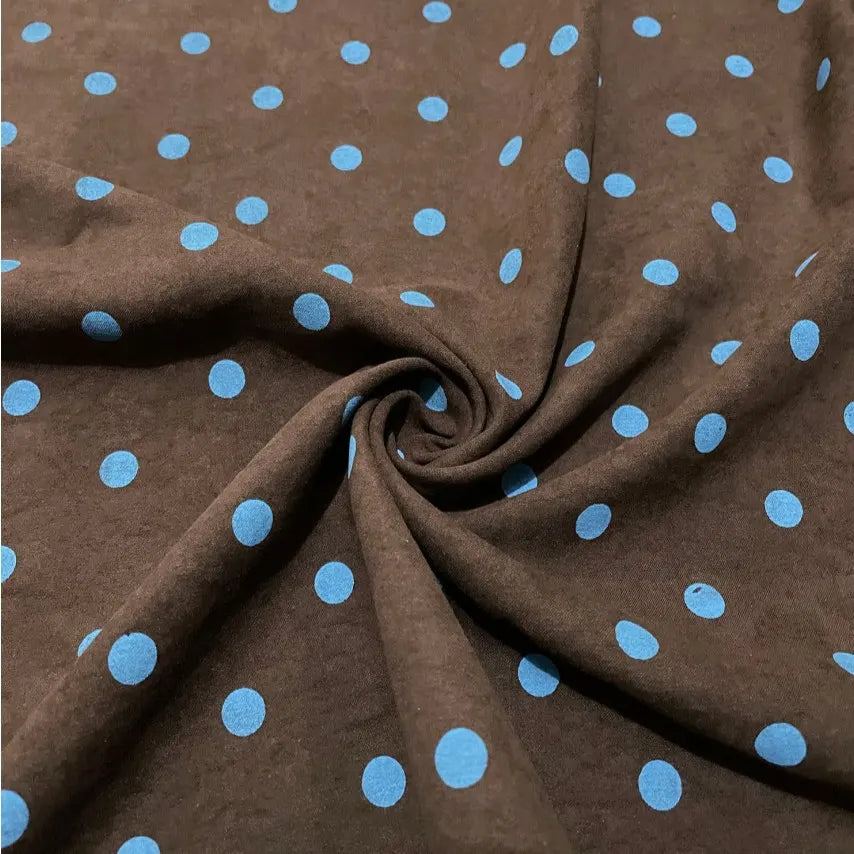 Polka Dot Printed Faux Suede Fabric By The Yard in brown with a blue polka dot pattern, gathered into a swirl in the center.