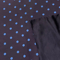 Polka Dot Printed Faux Suede Fabric By The Yard in dark faux suede with a pattern of light blue polka dots, shown with a folded corner revealing the solid dark underside.