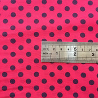 A metal ruler lies on Longan Craft’s Polka Dot Printed Peachskin Fabric By The Yard, a colorful microfiber polyester with black dots. The ruler shows measurements in centimeters and inches, the largest visible being 6 cm.