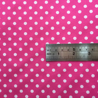 A metal ruler on Longan Craft Polka Dot Printed Peachskin Fabric shows the size of evenly spaced white dots. This colorful microfiber polyester material is perfect for DIY skirts and helps you visualize dot size for dressmaking projects.