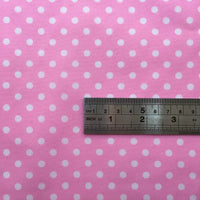A silver ruler rests on Longan Craft’s Polka Dot Printed Peachskin Fabric, showing centimeters and inches to display dot and fabric size—perfect for precise DIY skirts with this soft microfiber polyester material.