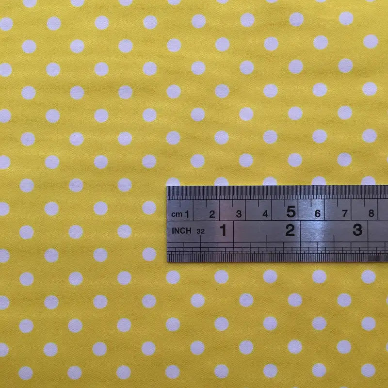 A metal ruler measuring up to 8 centimeters lies on Longan Craft’s Polka Dot Printed Peachskin Fabric By The Yard, a colorful microfiber polyester with soft peachskin texture—ideal for DIY skirts and precise dressmaking projects.