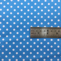 A metal ruler with inch and centimeter markings lies on Longan Craft’s Polka Dot Printed Peachskin Fabric—a colorful, soft microfiber polyester material with evenly spaced white dots, ideal for DIY skirts.