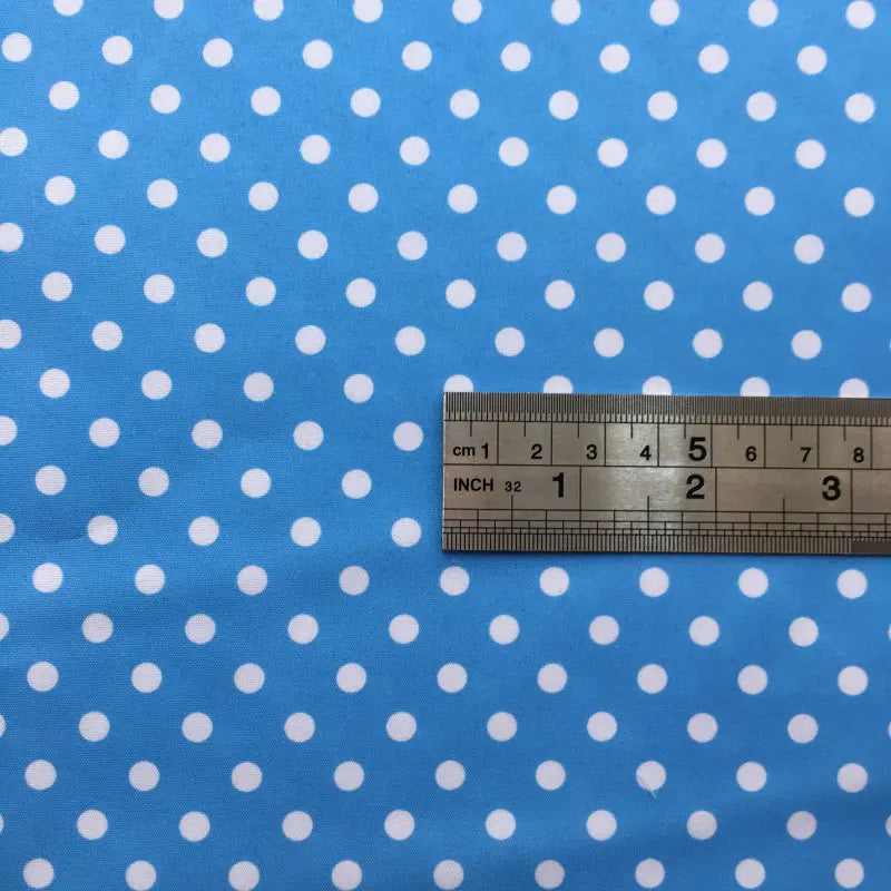 A metal ruler with inch and centimeter markings lies on Longan Craft’s Polka Dot Printed Peachskin Fabric—a colorful, soft microfiber polyester material with evenly spaced white dots, ideal for DIY skirts.