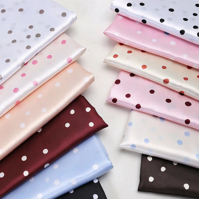 Two stacks of folded Polka Dot Printed Satin Fabric By The Yard in various colors, perfect for dressmaking.