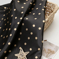 Polka Dot Printed Satin Fabric By The Yard draped over a woven basket.