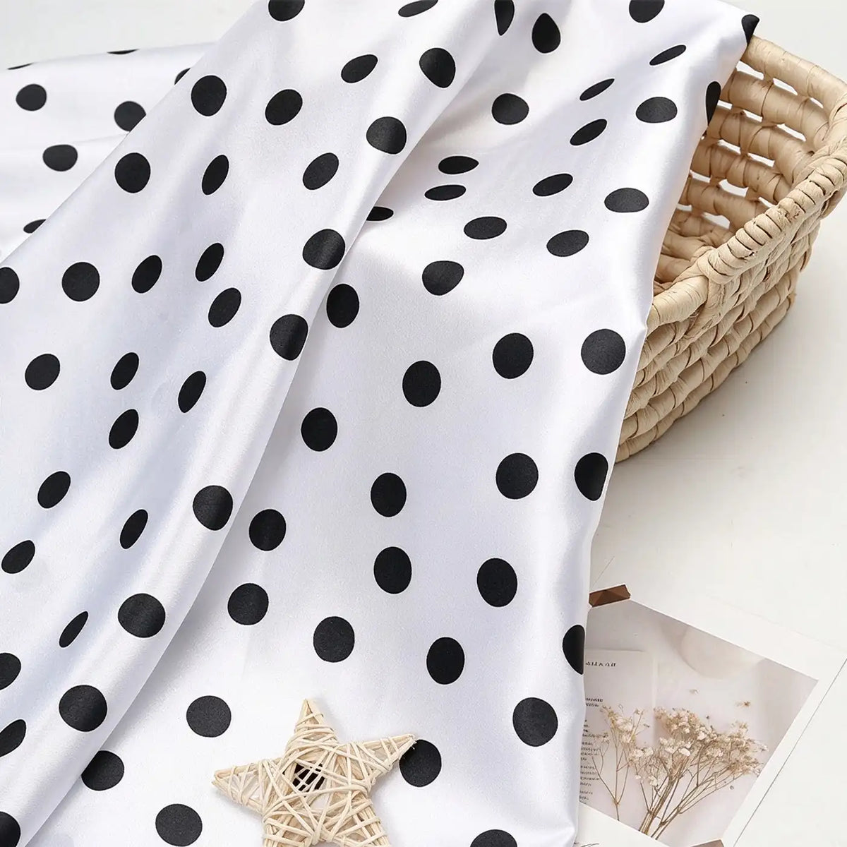 Polka Dot Printed Satin Fabric By The Yard draped over a woven basket.
