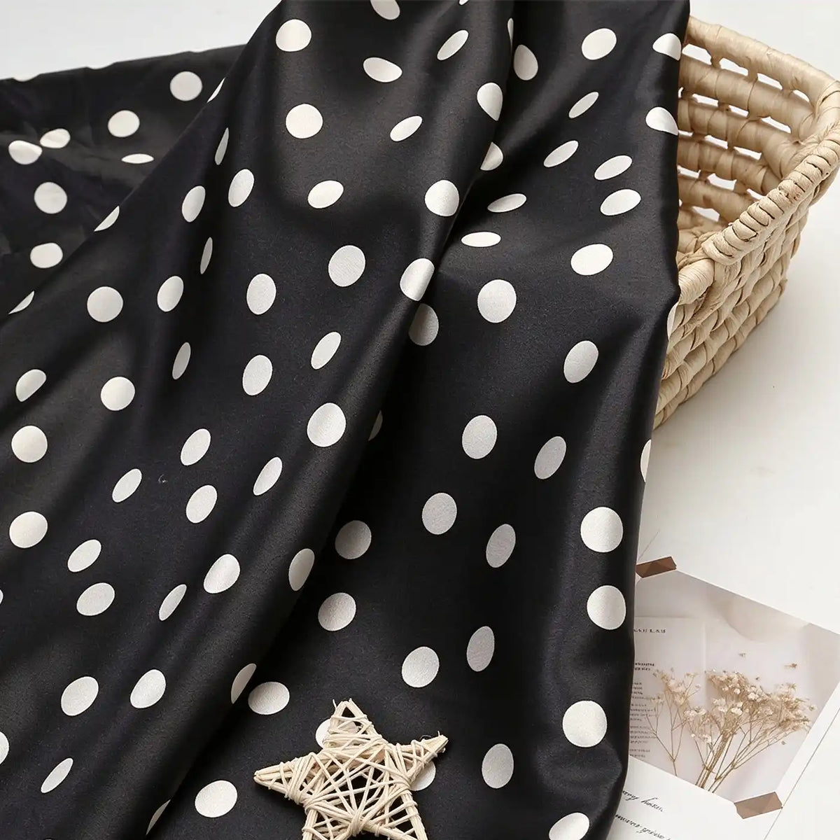 Polka Dot Printed Satin Fabric By The Yard draped over a woven basket.