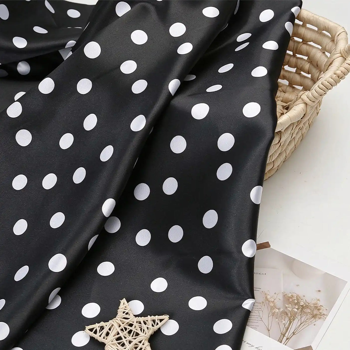 Polka Dot Printed Satin Fabric By The Yard draped over a woven basket.