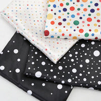Four folded pieces of Polka Dot Printed Satin Fabric By The Yard featuring various sizes and colors of polka dot patterns.