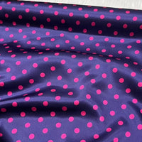Longan Craft's Polka Dot Stretch Silk Fabric By The Yard features a dark purple background with bold pink polka dots and a shiny, drapable 19 Momme finish—ideal for chic bridal wear or elegant evening gowns.