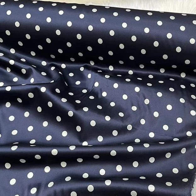 A close-up of Longan Craft’s Polka Dot Stretch Silk Fabric By The Yard showcases smooth, glossy 19 momme spandex silk with evenly spaced white dots on navy, perfect for vintage clothing, bridal wear, or elegant evening gowns.