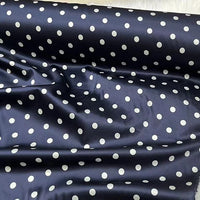 A close-up of Longan Craft’s Polka Dot Stretch Silk Fabric By The Yard showcases smooth, glossy 19 momme spandex silk with evenly spaced white dots on navy, perfect for vintage clothing, bridal wear, or elegant evening gowns.