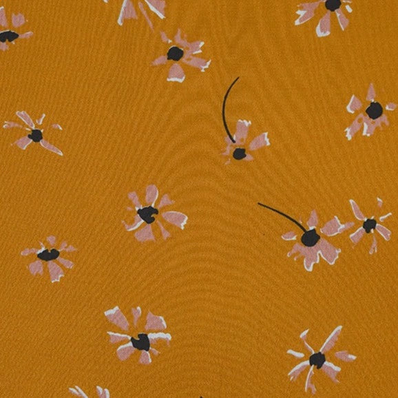 Polka Dot and Floral Printed Viscose Fabric by Longan Craft features abstract pink and white flowers with black centers on mustard yellow—perfect for creative sewing projects like long skirts. 100% viscose, available by the yard.