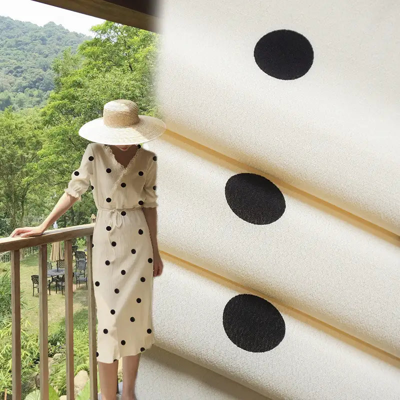 A person in a white dress with black polka dots made from Longan Craft’s Polka Dot and Floral Printed Viscose Fabric By The Yard stands on a balcony; next to them is a close-up of this fashionable 100% viscose material for long skirts.