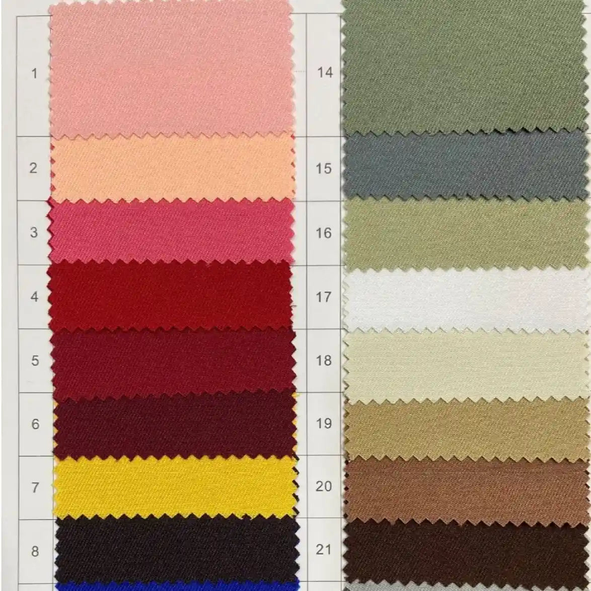 The Longan Craft Polyester Gabardine Fabric swatch card features 21 numbered color samples in three columns, displaying a range of plain twill shades from pinks and reds to yellows, blues, greens, and neutrals.