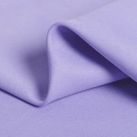 A close-up of Longan Craft’s Polyester Gabardine Fabric By The Yard shows smooth, wrinkle-resistant light purple twill with soft folds and fine diagonal lines—ideal premium material for stylish jackets.